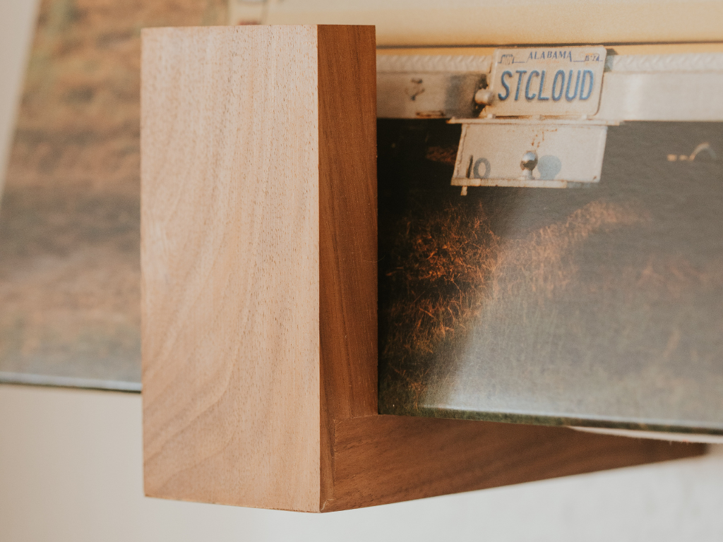 A close up of a walnut record shelf mounted on the wall holding vinyl records