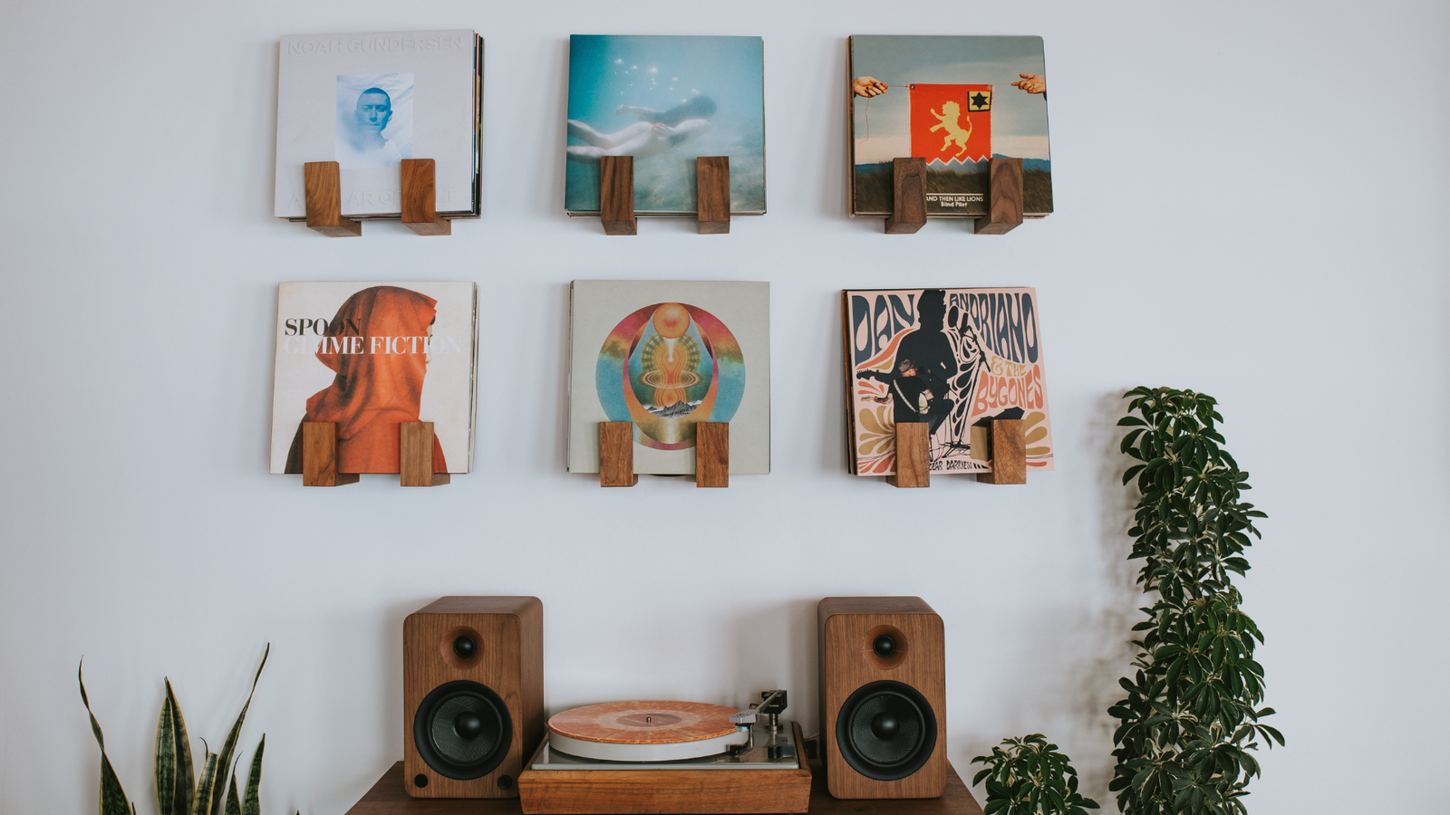 Record display wall with Flip Record Display Shelves by Deep Cut above a vintage Bogen B52 record player and modern speakers in walnut on a floating record player table