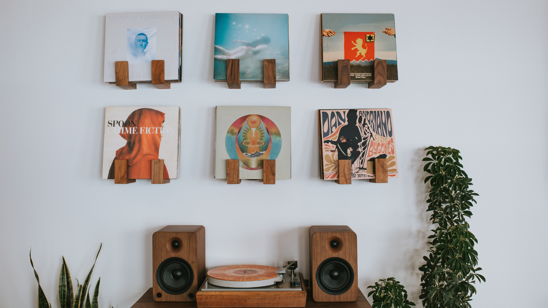 Record display wall with Flip Record Display Shelves by Deep Cut above a vintage Bogen B52 record player and modern speakers in walnut on a floating record player table
