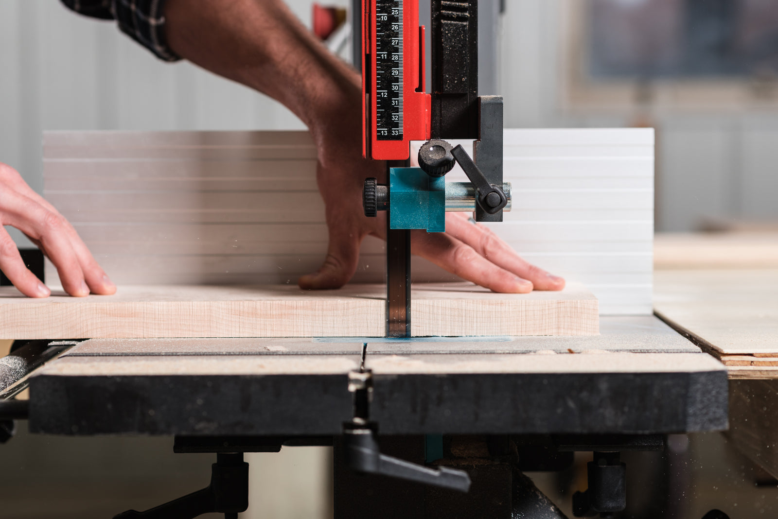 A man pushing lumber through a saw hand-making record shelving in a Minnesota woodshop