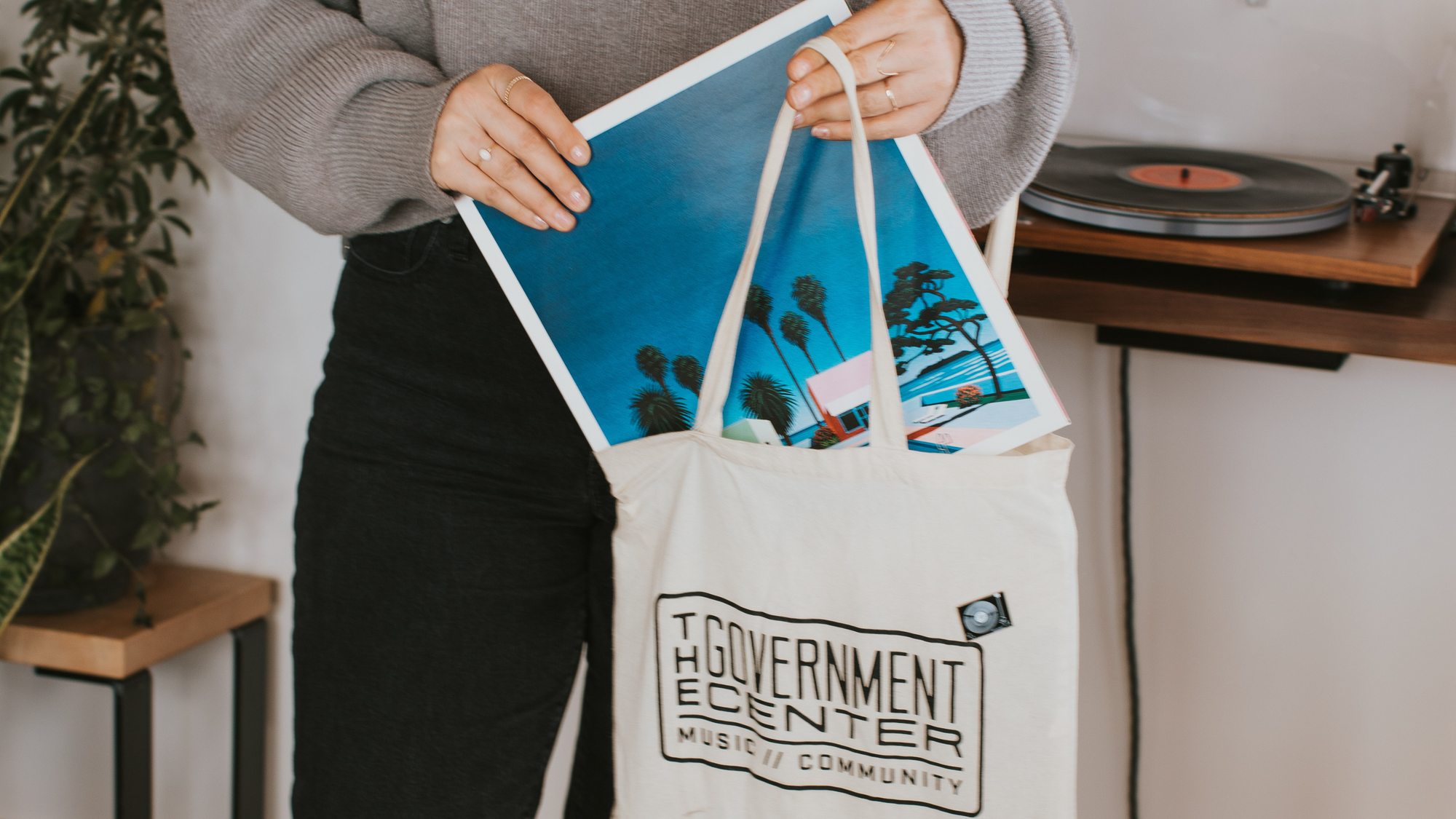 A woman pulling records out of a Government Center Record Store record bag from a Curated Bag of Records from Deep Cut